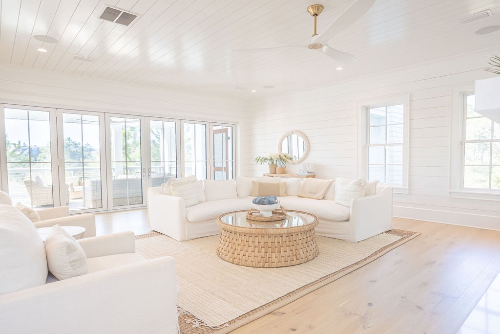 Modern coastal living room with direct access to a screened patio and gar fire pit.