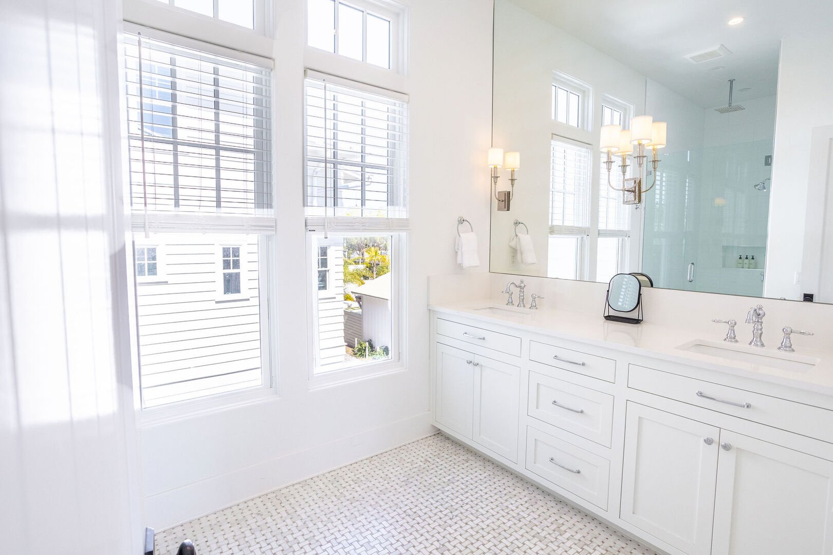 Bathroom has dual vanities and large walk-in shower.