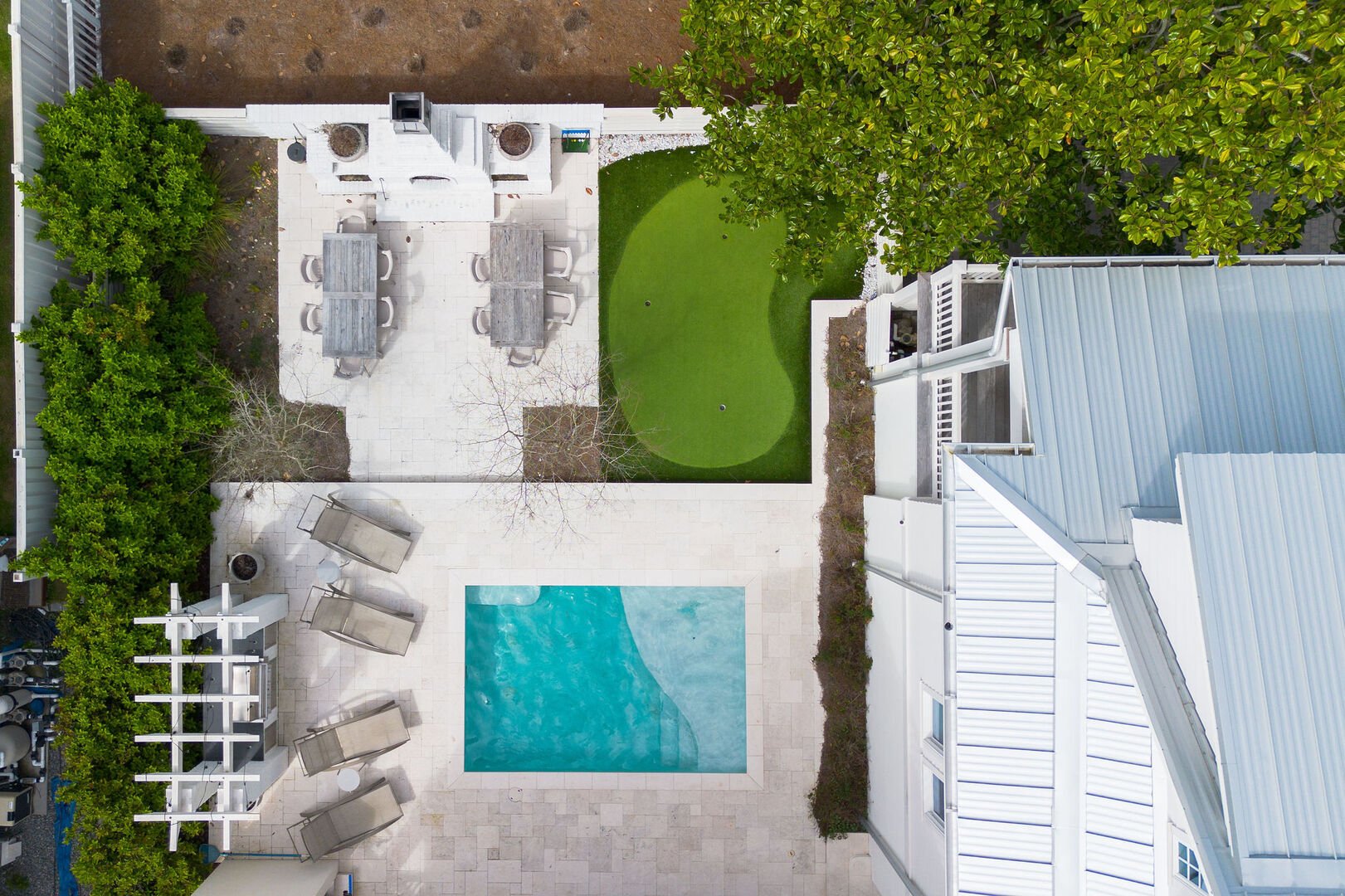 Beautiful outdoor space complete with heated pool, outdoor dining, fireplace, outdoor kitchen, & putting green!