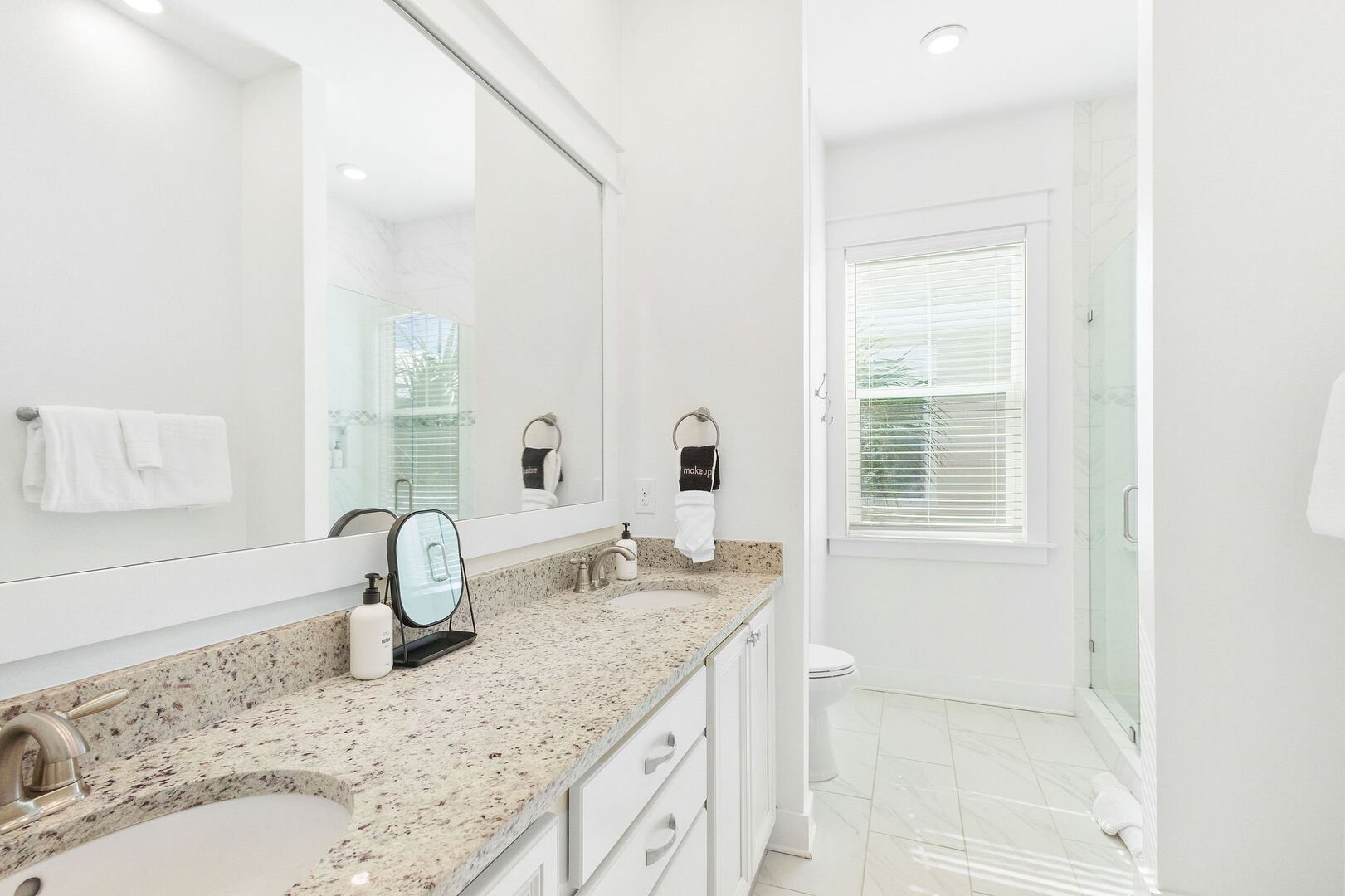 Bathroom features dual vanities and a walk-in shower.