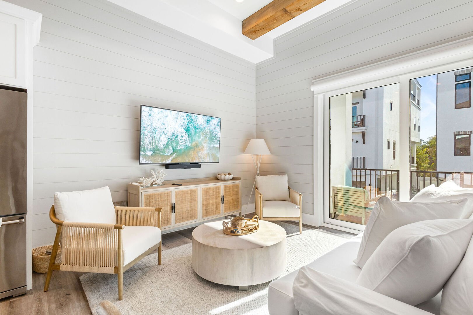 Living room features a smart tv and balcony access.
