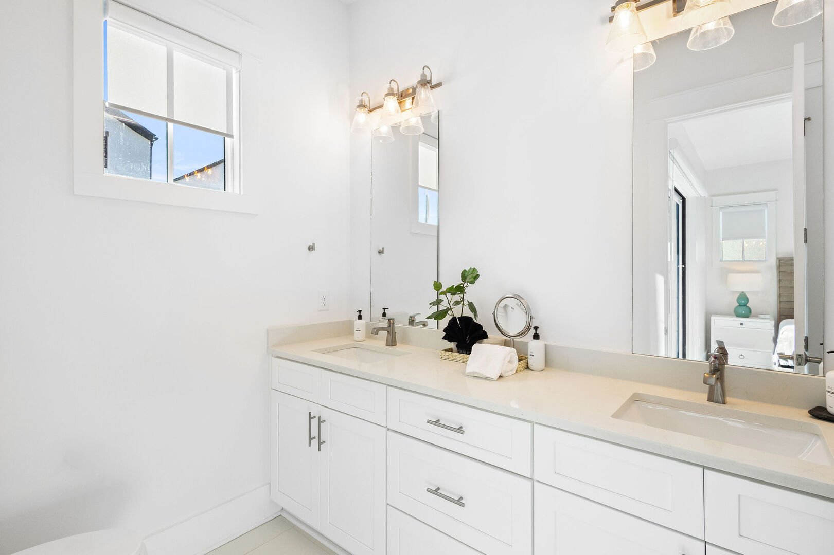 Bathroom features dual vanities and a walk-in shower.