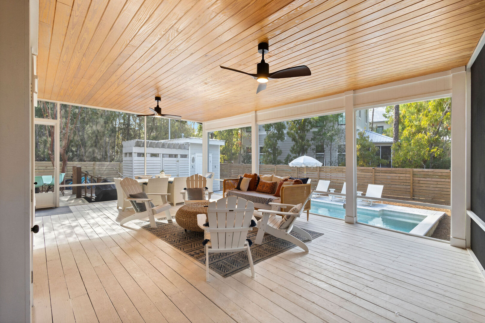 Large screened in porch features lounging area and outdoor dining space.