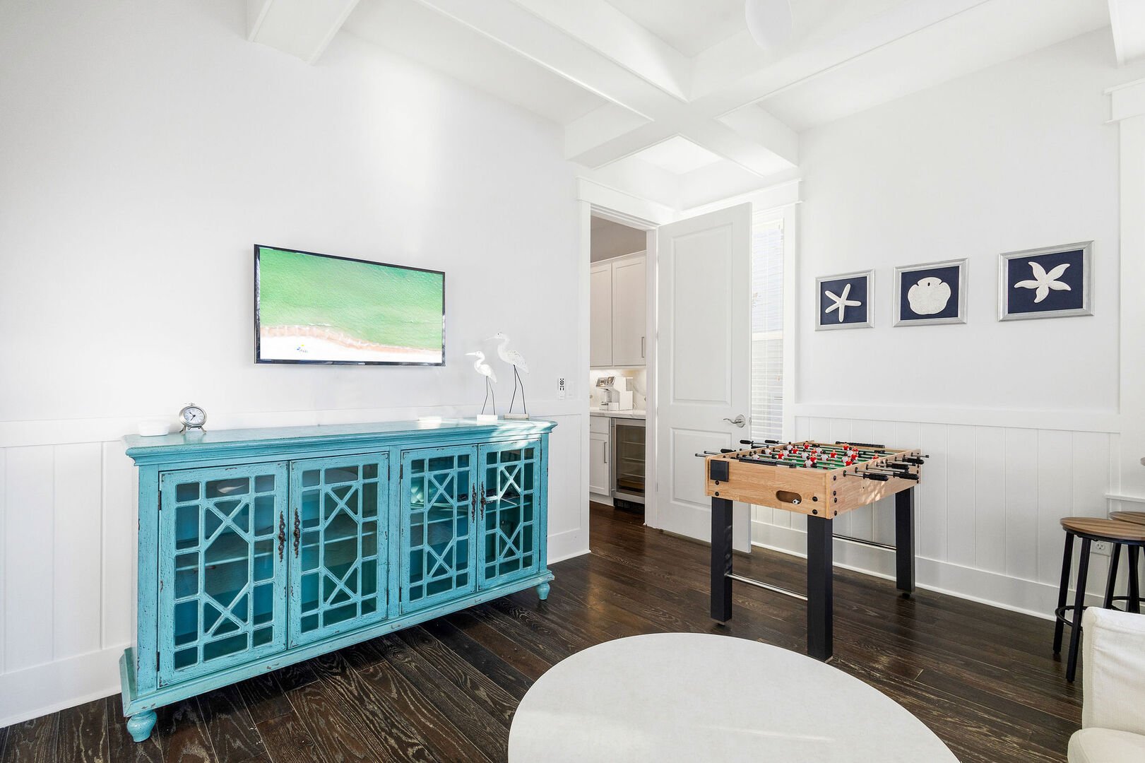 Game room features a foosball table, smart tv and seating.