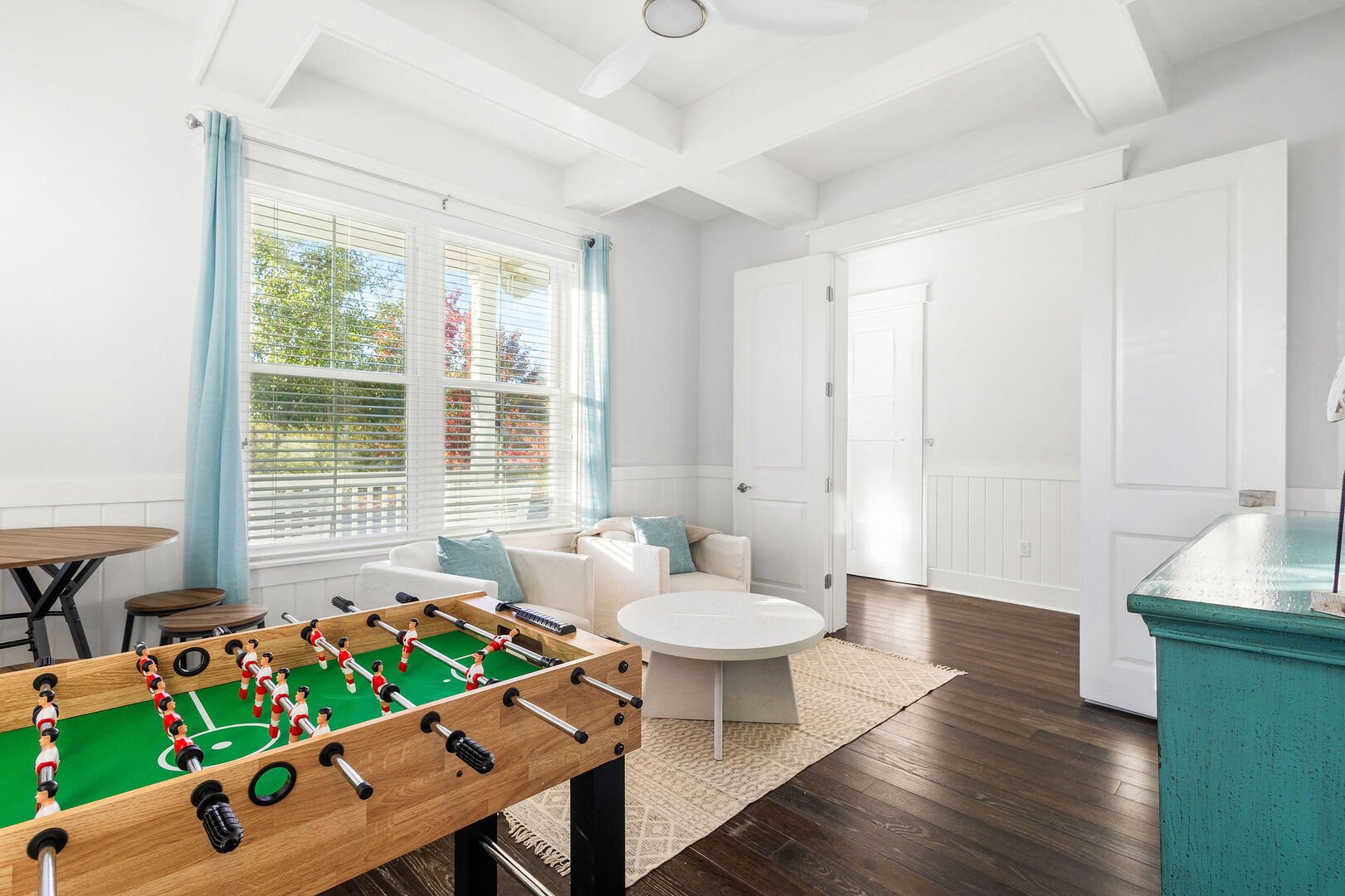 Sitting area and game room, features a smart tv and foosball table.