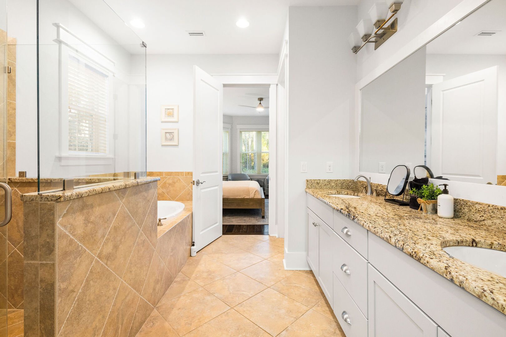 Bathroom features dual vanities, walk-in shower and soaker tub.