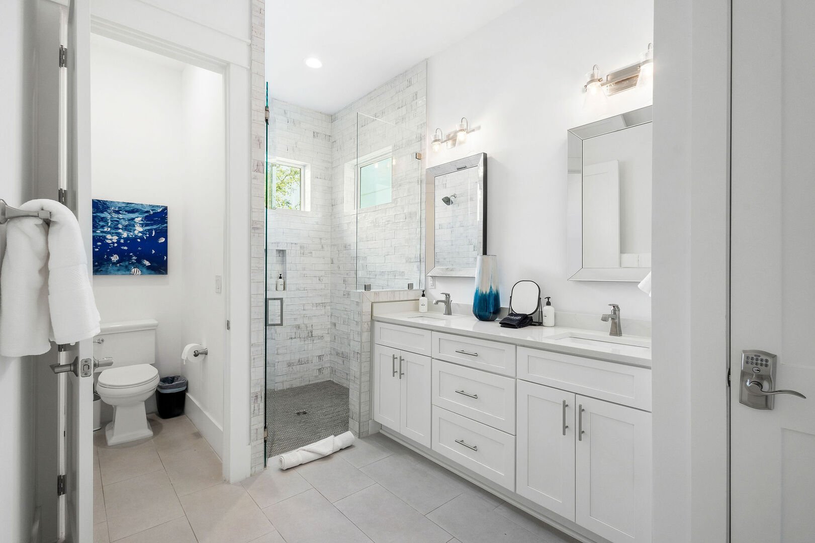 Bathroom features dual vanities and a large walk-in shower.