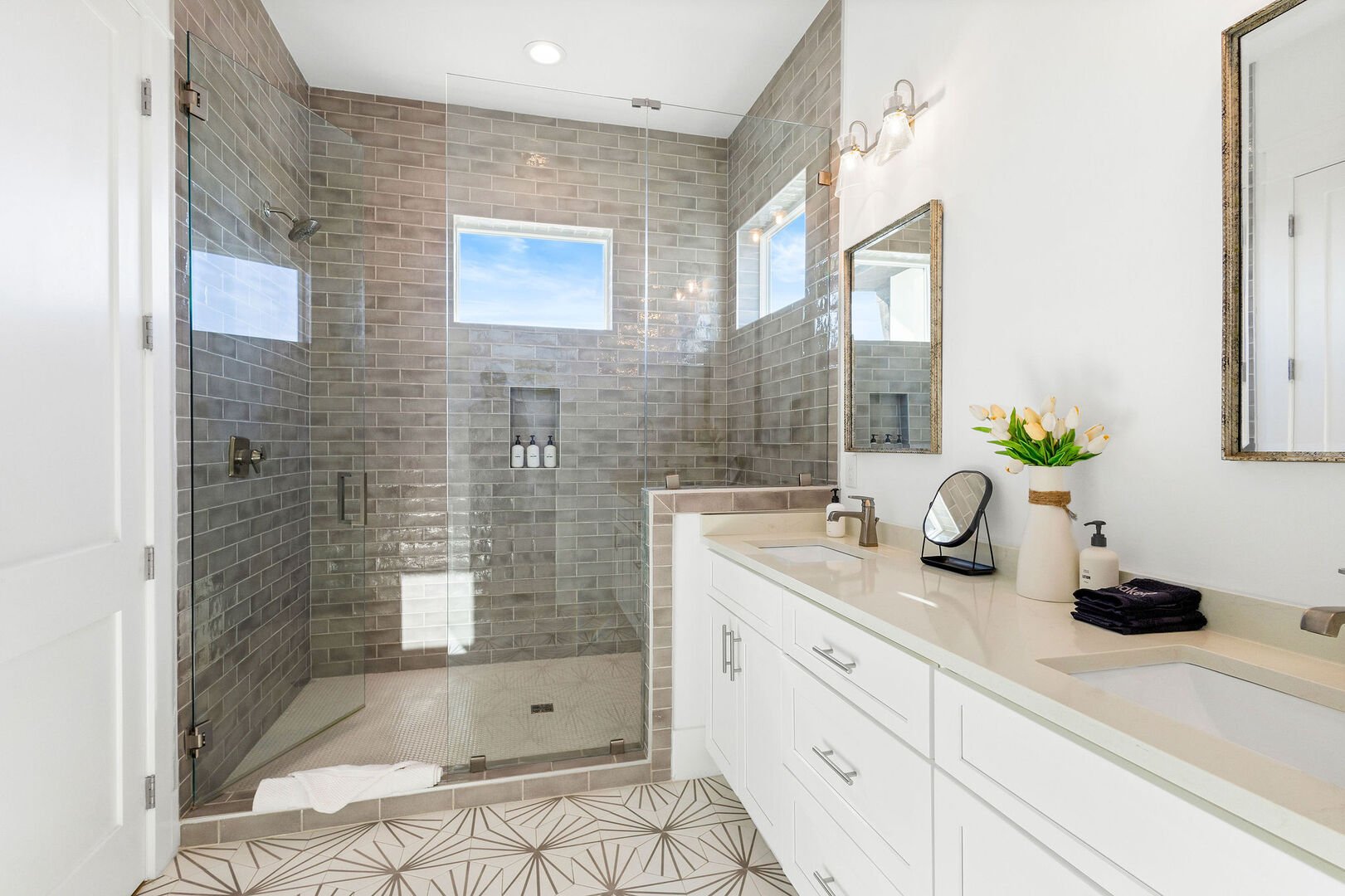 Bathroom features dual vanities and a large walk-in shower.