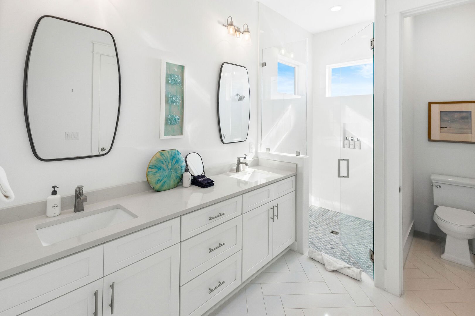 Bathroom features dual vanities and walk-in shower.