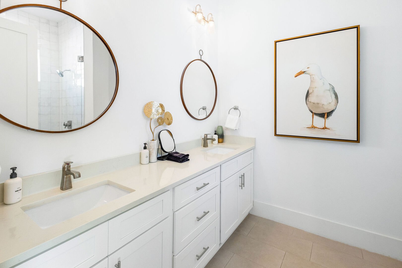 Bathroom features dual vanities and a walk-in shower.