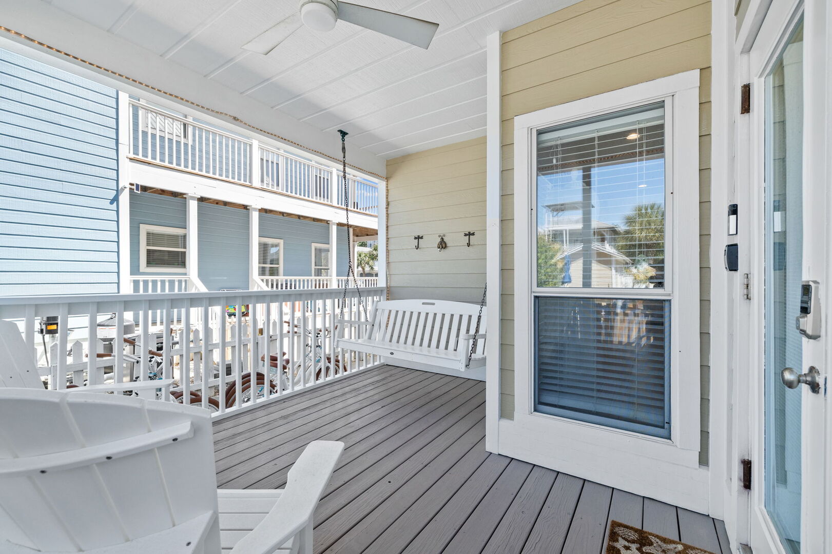 Covered back porch off living room features a few seating options.