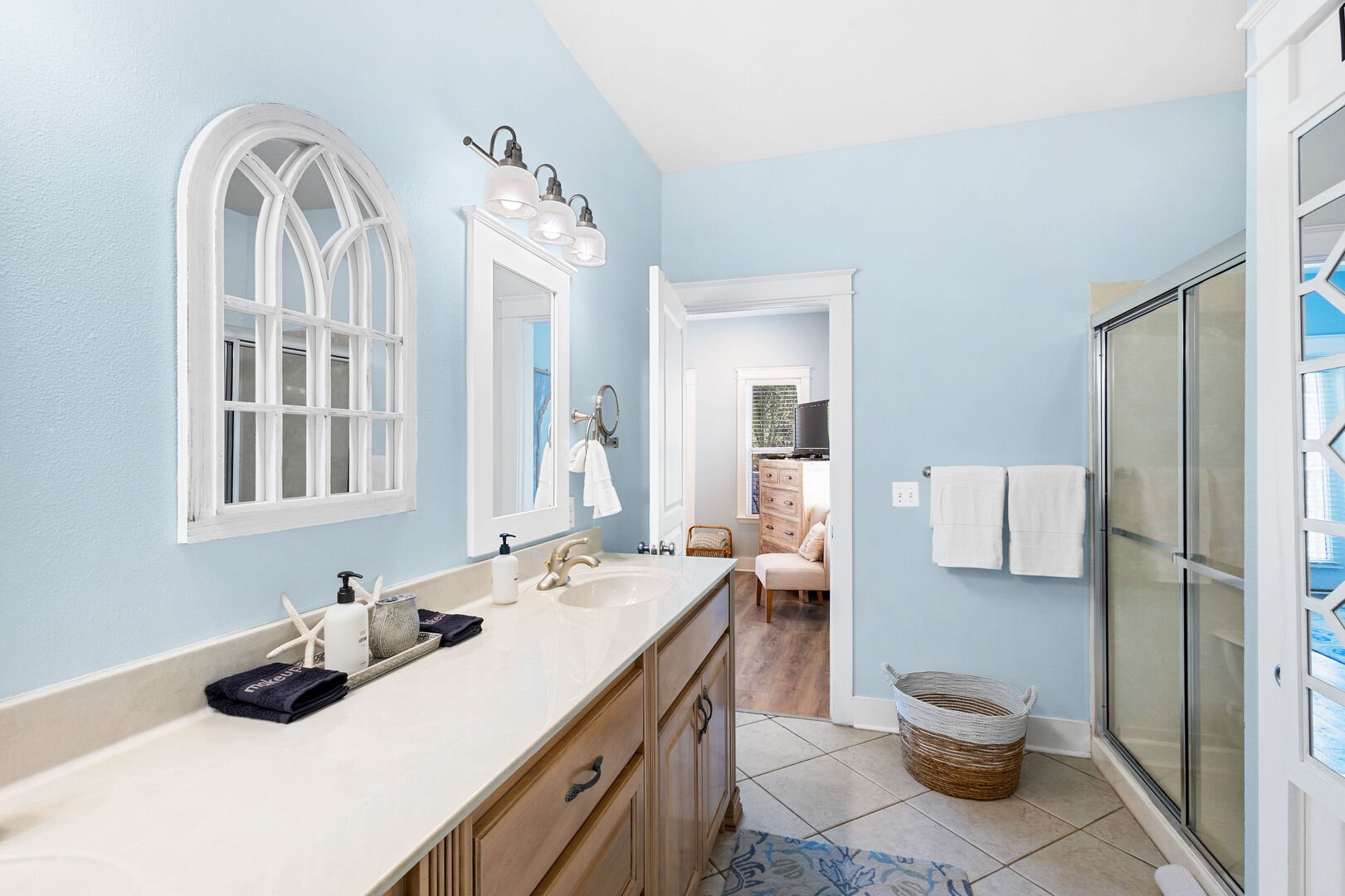 Bathroom features dual vanities with a walk-in shower.