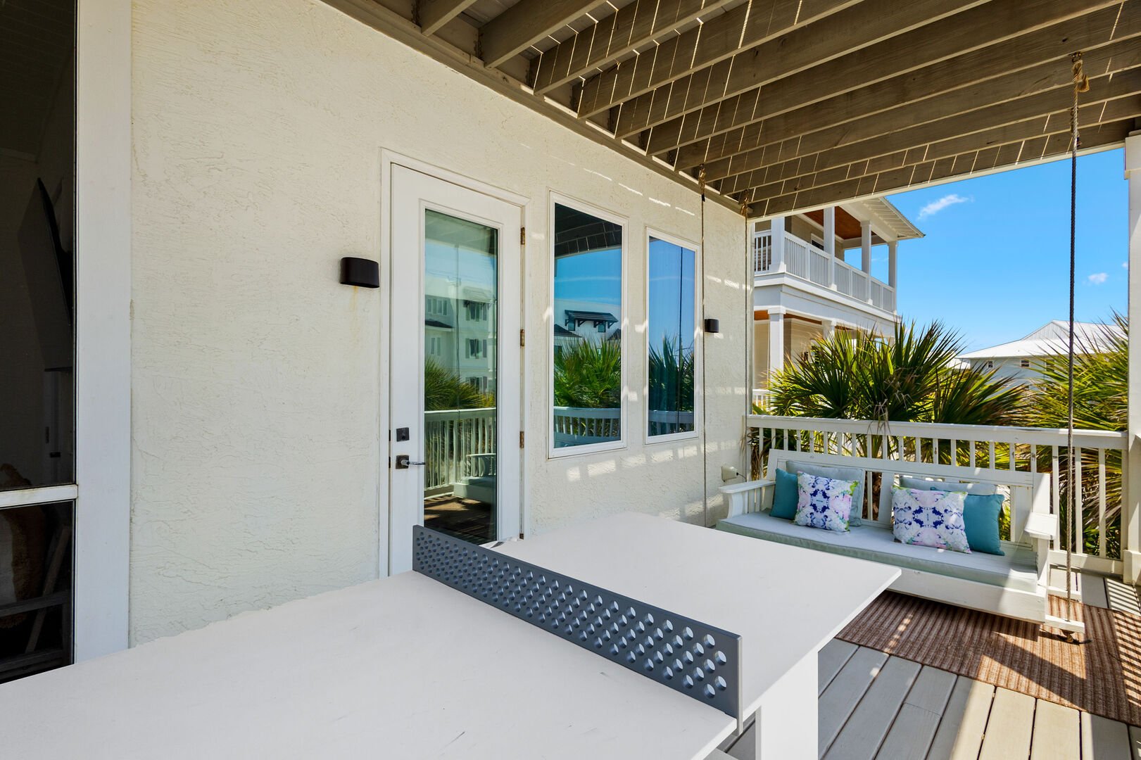 Second floor balcony features a ping pong table, seating and gulf vies.