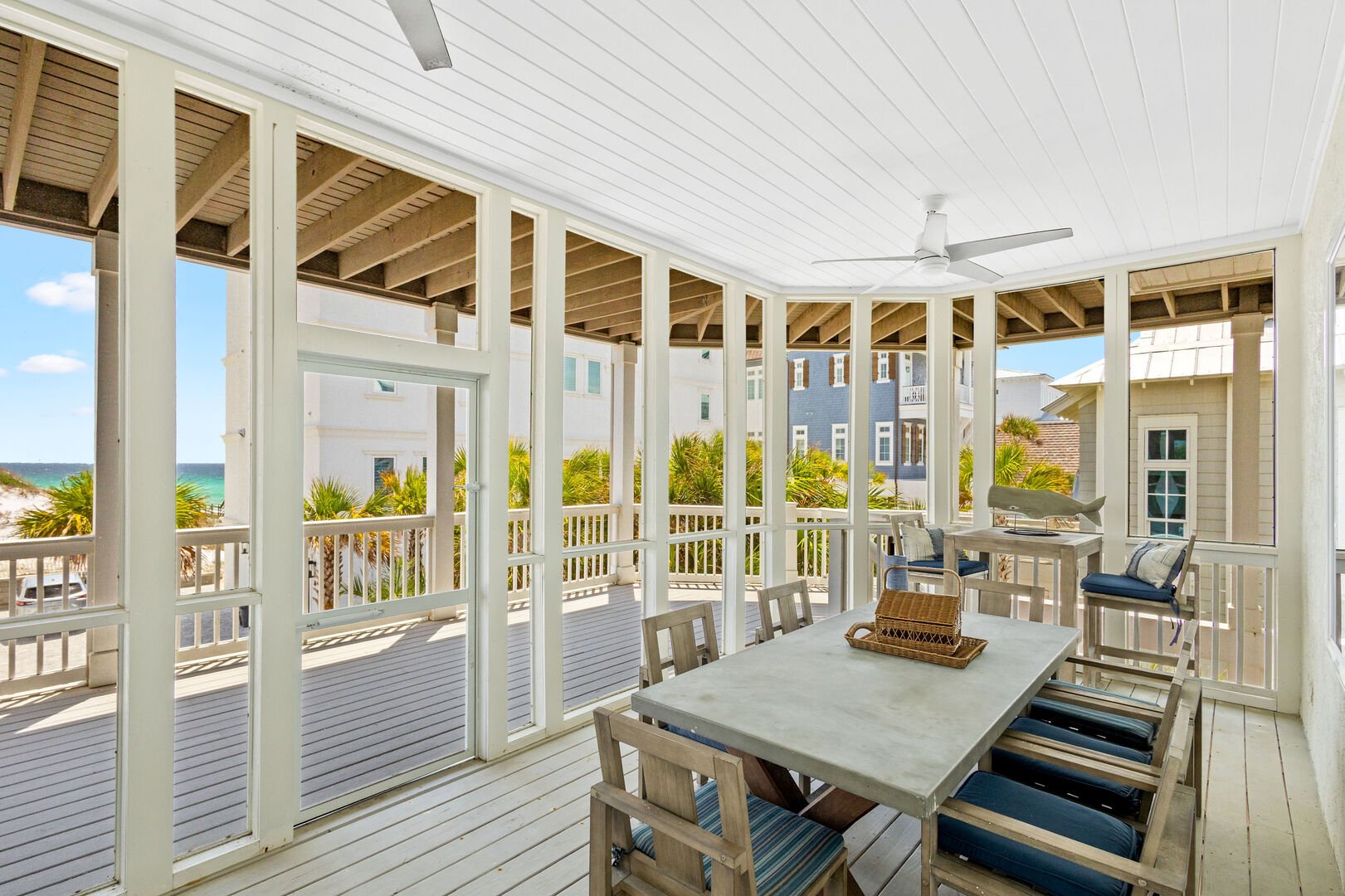 Second floor balcony features a screened in dining area with seating for 5 with a smart tv.