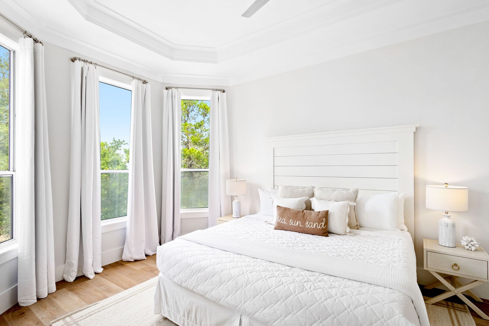 Wake up to natural light and stunning views in this serene second floor primary bedroom, featuring oversized windows and a peaceful, airy vibe.