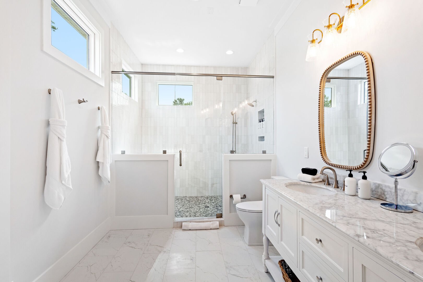 Bathroom features a large walk-in shower and dual vanities.